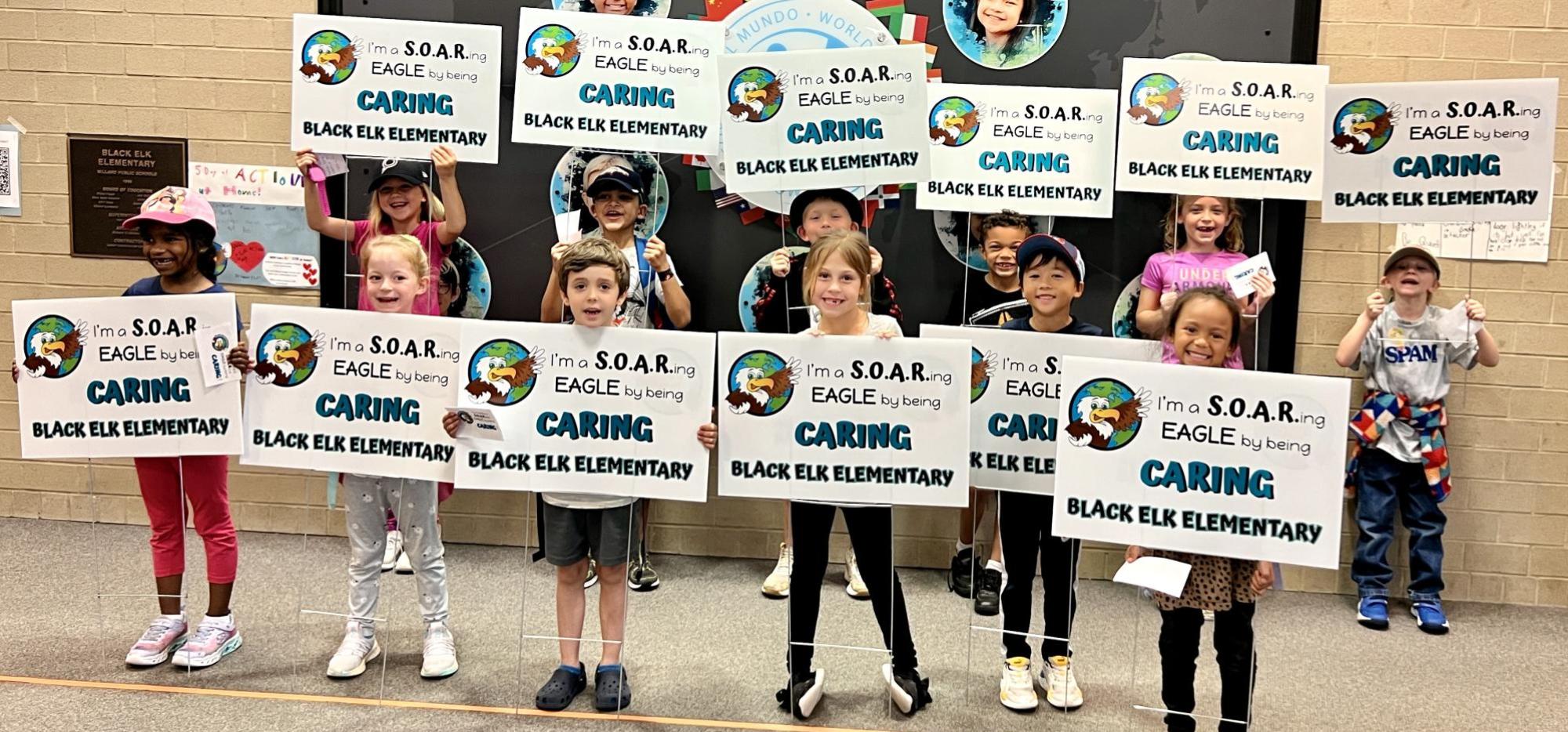 students holding caring signs